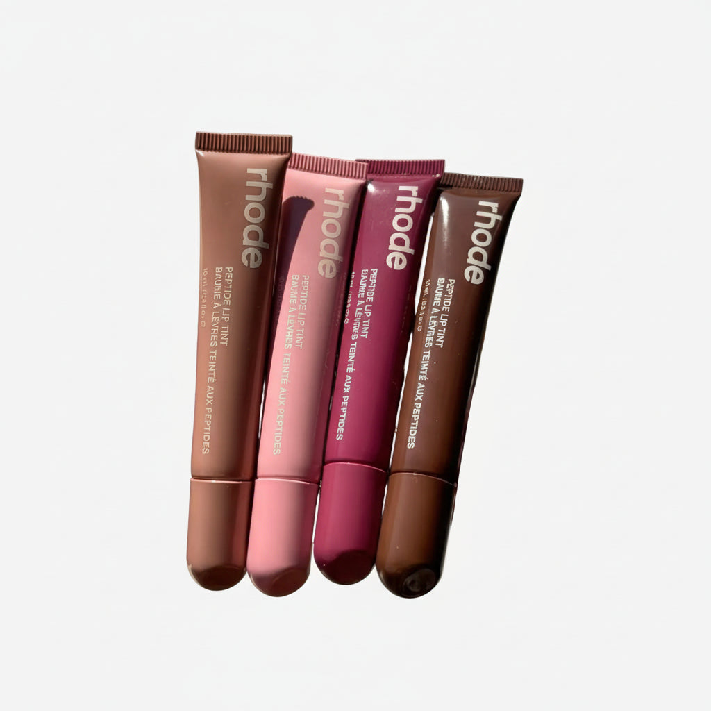 Three lip tint tubes from the brand 'rhode' on a neutral background